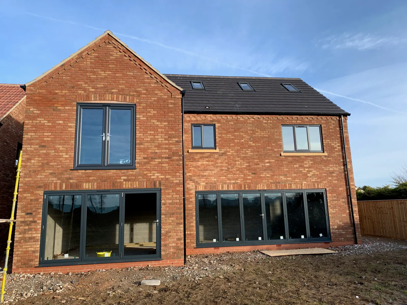 PM Windows installation: Dark bi-fold doors across a contemporary extension